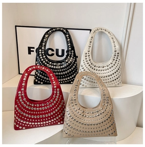 Detail showing four colors of studded hobo bags on minimalist white display stands