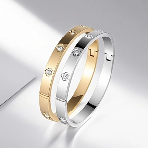 Detailansicht polierter Armreifen aus Gold und Silber mit floralen Gravuren und Zirkonia