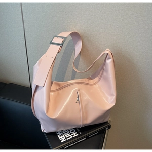 Détail du sac hobo rose brillant avec bandoulière large et boucle en métal argenté