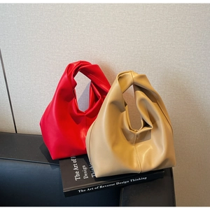 Detailed view of the knotted handles and pleated texture of semi-circle handbags