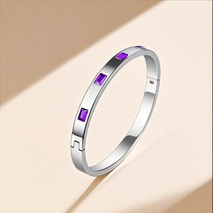 Close-up of a silver stainless steel bangle with inlaid rectangular purple gemstones