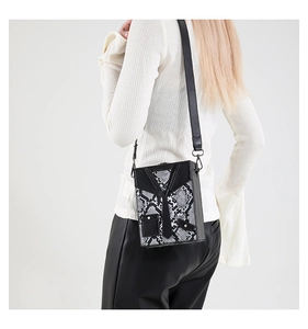 Detail of snake skin pattern crossbody bag with creative tie design on male model