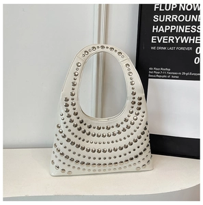 Close-up of a white hobo bag featuring polished silver studs and glossy leather finish
