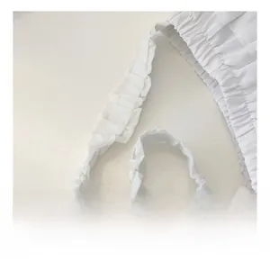 Detailed macro view of white chiffon ruffled elastic straps and soft pleated fabric