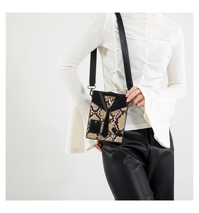 Detail of unique box bag with jacket shape design and snakeskin texture on model