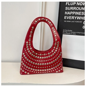 Detail of red crescent bag featuring silver rivet studs and glossy finish texture