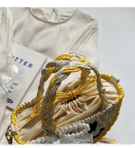 Detailed straw handbag weave with lace trim, pearl handle, and smiling face design