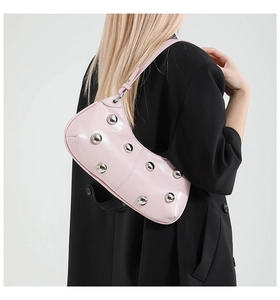 Détail du sac en cuir rose avec rivets métalliques argentés et bandoulière élégante