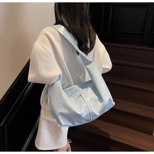 Détail du sac cabas bleu clair en cuir verni brillant avec large bandoulière