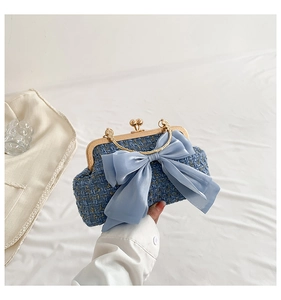 Close-up of blue tweed evening bag with satin bow and vintage gold metal clasp