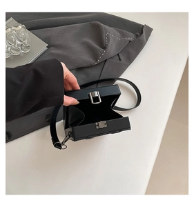 Internal view of the black box crossbody bag showing structured compartment and clasp