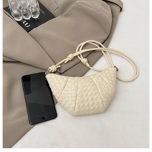 Detail of hand-woven cream leather dumpling bag with smartphone for size reference