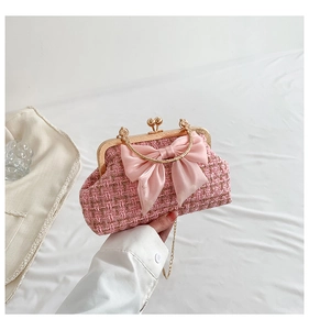 Detail of pink tweed clutch with large silk bow and gold metal chain strap