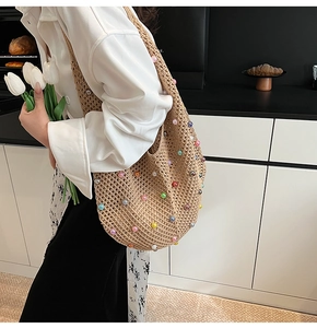 Detail of hand-crocheted beach bag with colorful faux pearls and woven texture