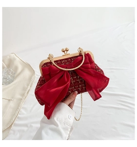 Detail of red tweed evening bag with silk bow and vintage gold metal clasp handle