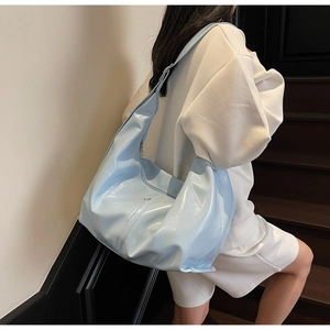 Gros plan d'un sac à bandoulière bleu clair brillant au design minimaliste chic
