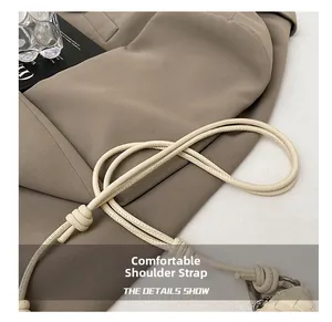 Detail of a creamy white woven bag showing fine leather strap and stylish knotted craftsmanship