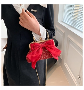 Detailed texture of red tweed evening bag with silk bow and metal ring handle