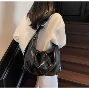 Vue détaillée du grand sac hobo en cuir verni noir avec boucle en métal argenté réglable