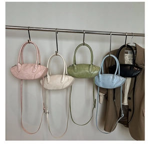 Five olive-shaped crossbody bags in pink, beige, green, blue and black on metal hangers