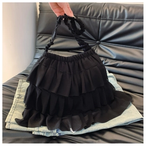 Detail of layered black ruffle tote bag with tiered pleated chiffon and ruched handle design