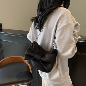 Elegant black satin bow crossbody bag with silver metal chain strap for stylish women