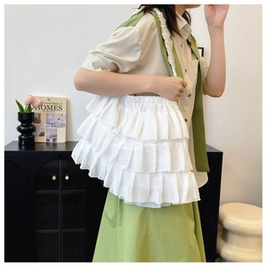 Detailed view of white tiered ruffle tote bag styled with casual spring fashion outfit