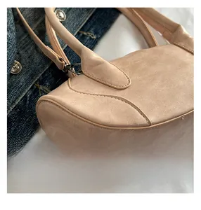 Detailed close-up of apricot textured leather handbag with precise reinforced stitching