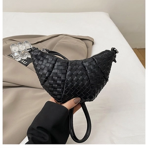 Detail of the black hand-woven leather texture and zipper on the crescent handbag