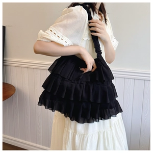 Detail of layered ruffle design and textured fabric on black ballet style tote bag