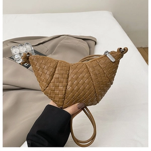 Detail of caramel brown woven leather croissant bag with metallic zipper and premium texture