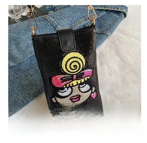 Détail du sac à bandoulière pailleté avec fille de dessin animé brodée et fermoirs dorés