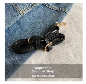 Détails macro de la bandoulière réglable en cuir noir avec mousquetons en métal doré