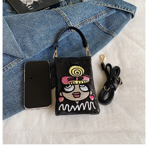 Détail du sac à paillettes avec fille de dessin animé, crochets dorés et bandoulière