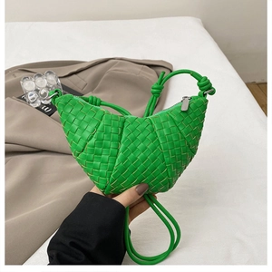Detail of green woven leather dumpling bag featuring knot shoulder strap and silver zipper