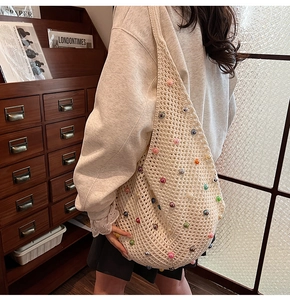 Detail of hand-crocheted hollow net shoulder bag featuring colorful pearl decorations