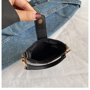 Détail de la pochette téléphone en cuir noir montrant la doublure et le fermoir doré