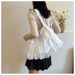 Detail shot of white tiered ruffled tote bag showing soft fabric texture and layered design