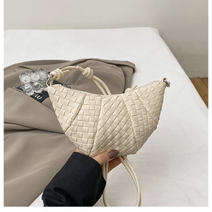 Detail shot of ivory hand-woven dumpling bag featuring premium cross-weave leather texture