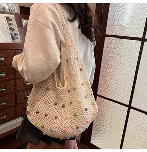 Detail of crochet knit shoulder bag with colorful beads and hollow mesh pattern