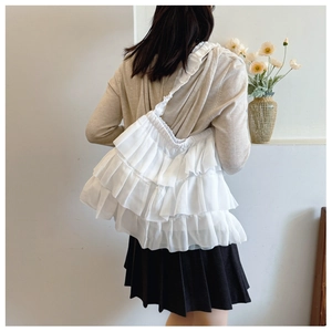 Detailed view of white tiered ruffle lace tote bag featuring elegant layered frill design