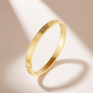 Macro detail of 18K gold-plated stainless steel bracelet with Greek meander pattern