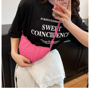 Close-up of hot pink hand-woven dumpling bag with braided texture and knotted strap