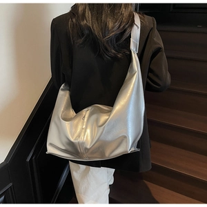 Sac à bandoulière argenté en forme de croissant avec finition métallique sur modèle