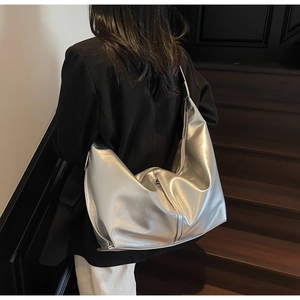 Détail d'un sac hobo argenté métallisé en cuir texturé avec fermeture éclair verticale