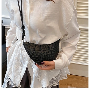 Detail of black woven crossbody bag with knotted strap and premium leather texture
