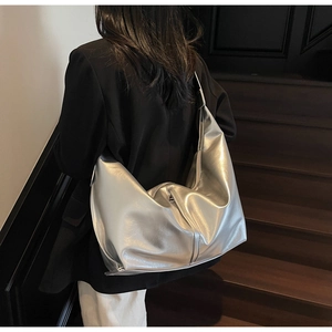 Vue d'épaule d'un grand sac cabas argenté métallisé avec texture miroir plissée