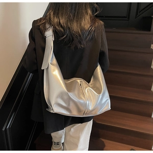 Détail du sac hobo métallisé argent avec bandoulière réglable et design à glissière