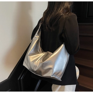 Détail du grand sac hobo argenté montrant la texture souple en similicuir métallique