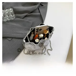 Silver bucket bag with skull relief detailing showing internal capacity and metal chain